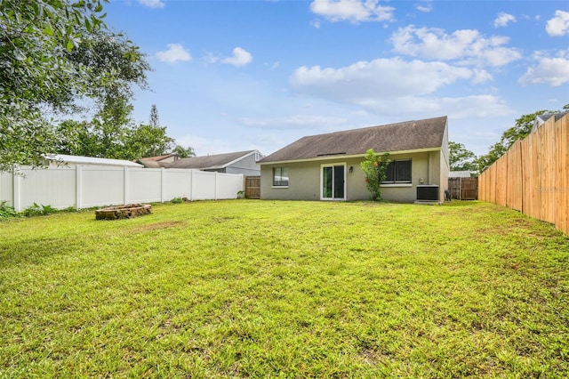 12315 Hidden Brook Dr, Tampa, FL 33624 - rear view of property featuring stucco siding, a fenced backyard, a fire pit, and a shingled roof