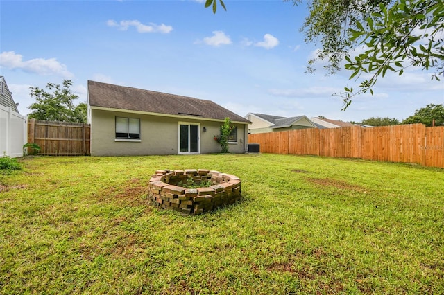 12315 Hidden Brook Dr, Tampa, FL 33624 - back of house with a fire pit, stucco siding, a fenced backyard, and roof with shingles
