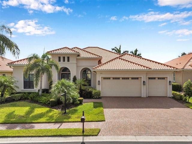 1042 Tuscany Dr, Trinity, FL 34655 - mediterranean / spanish-style home featuring an attached garage, stucco siding, a tile roof, driveway, and a front yard