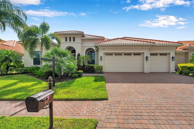 1042 Tuscany Dr, Trinity, FL 34655 - mediterranean / spanish-style house featuring stucco siding, a garage, driveway, a tiled roof, and a front yard