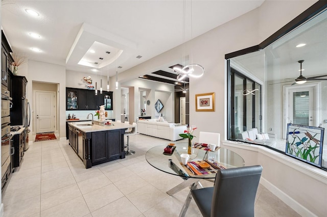 1042 Tuscany Dr, Trinity, FL 34655 - kitchen featuring open floor plan, dark cabinetry, light countertops, pendant lighting, and a kitchen breakfast bar