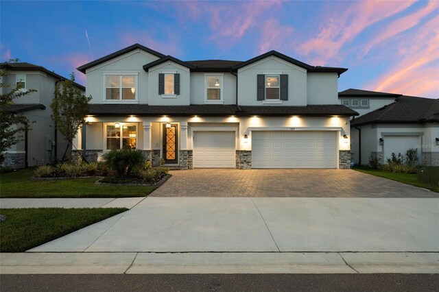 7819 Notched Pine Bnd, Wesley Chapel, FL 33545 - view of front of property featuring stucco siding, an attached garage, driveway, and stone siding