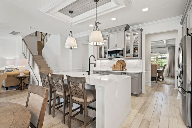 7819 Notched Pine Bnd, Wesley Chapel, FL 33545 - kitchen featuring gray cabinets, appliances with stainless steel finishes, light countertops, backsplash, and crown molding