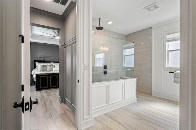 7819 Notched Pine Bnd, Wesley Chapel, FL 33545 - bathroom with a decorative wall, crown molding, ceiling fan, a walk in shower, and wood finished floors