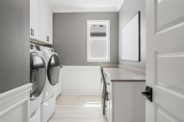 7819 Notched Pine Bnd, Wesley Chapel, FL 33545 - laundry room featuring separate washer and dryer, cabinet space, light wood finished floors, wainscoting, and ornamental molding