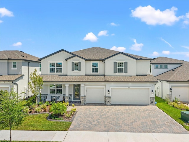 7819 Notched Pine Bnd, Wesley Chapel, FL 33545 - view of front of house featuring stucco siding, an attached garage, decorative driveway, and stone siding