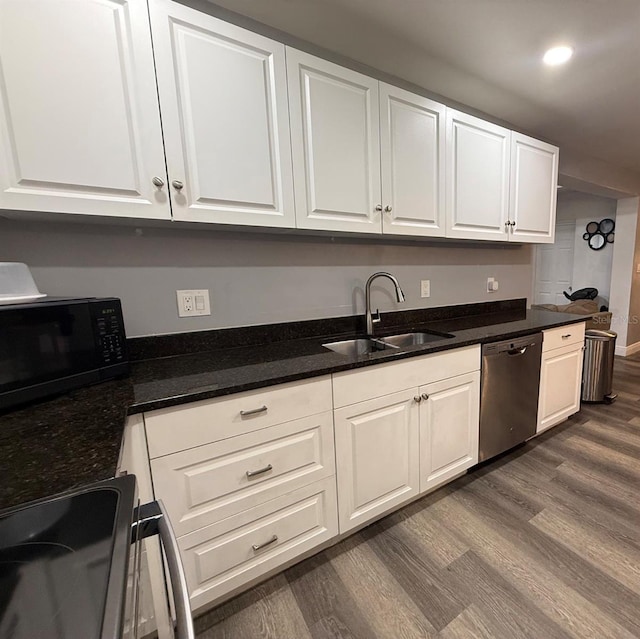 2813 W Kenmore Ave, Tampa, FL 33614 - kitchen featuring stainless steel dishwasher, dark wood-type flooring, black microwave, range, and white cabinetry