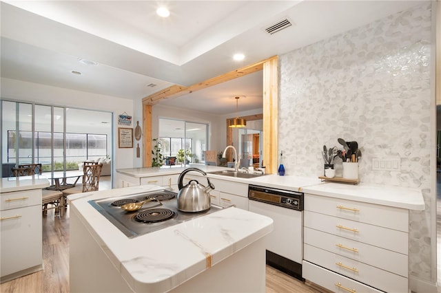 4719 61st Avenue Terrace W Unit 4719, Bradenton, FL 34210 - kitchen with white dishwasher, stainless steel electric stovetop, light wood finished floors, white cabinetry, and healthy amount of natural light