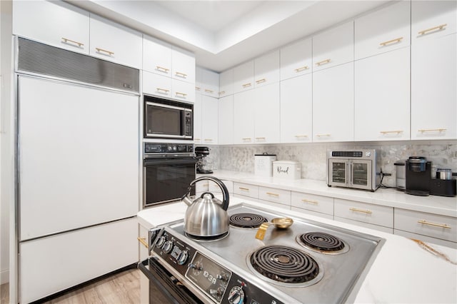 4719 61st Avenue Terrace W Unit 4719, Bradenton, FL 34210 - kitchen with refrigerator, black oven, stainless steel range with electric cooktop, built in microwave, and light countertops
