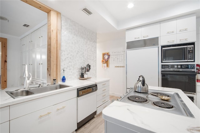 4719 61st Avenue Terrace W Unit 4719, Bradenton, FL 34210 - kitchen with built in appliances, light wood finished floors, and white cabinetry