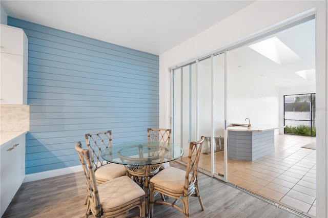4719 61st Avenue Terrace W Unit 4719, Bradenton, FL 34210 - dining space with wood walls, light wood-style flooring, and a skylight