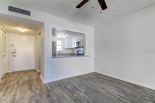 4901 Onyx Ln Unit 204, New Port Richey, FL 34652 - unfurnished living room featuring a ceiling fan, wood finished floors, and a textured ceiling