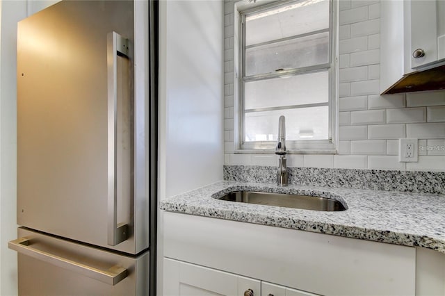 4901 Onyx Ln Unit 204, New Port Richey, FL 34652 - kitchen featuring freestanding refrigerator, white cabinetry, tasteful backsplash, and light stone counters