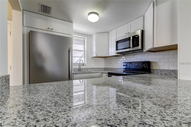4901 Onyx Ln Unit 204, New Port Richey, FL 34652 - kitchen featuring stainless steel appliances, light stone counters, tasteful backsplash, and white cabinets