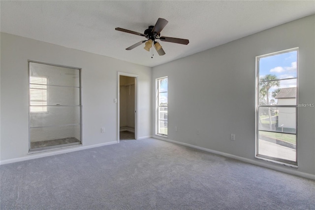 4901 Onyx Ln Unit 204, New Port Richey, FL 34652 - unfurnished bedroom featuring carpet, a spacious closet, ensuite bath, and a ceiling fan