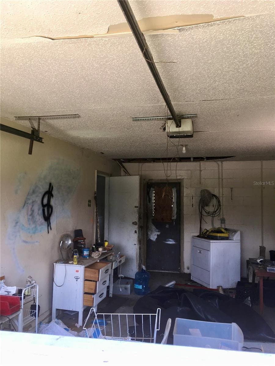 2532 Elm Ave, Lake Wales, FL 33898 - garage featuring a garage door opener, washer / dryer, and concrete block wall