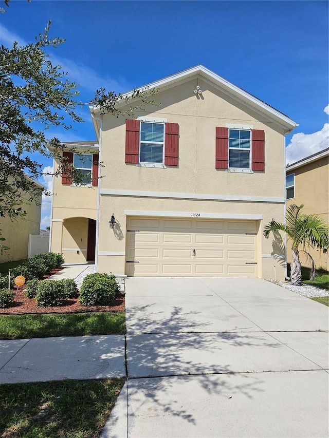 10124 Mangrove Well Rd, Ruskin, FL 33573 - traditional-style house with stucco siding, a garage, and concrete driveway