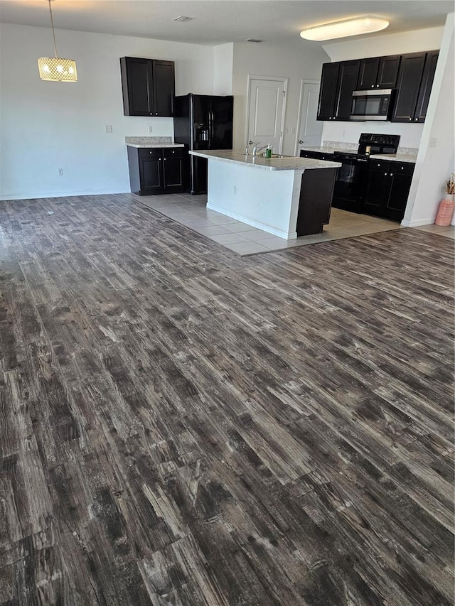 10124 Mangrove Well Rd, Ruskin, FL 33573 - kitchen featuring black appliances, dark wood-style floors, open floor plan, and dark cabinets