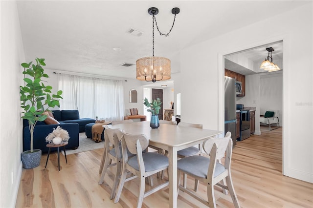 1720 Patlin Cir N, Largo, FL 33770 - dining room with light wood-style floors and a chandelier