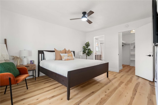 1720 Patlin Cir N, Largo, FL 33770 - bedroom featuring light wood-type flooring, a walk in closet, a closet, a ceiling fan, and connected bathroom