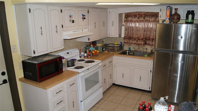7705 Embassy Blvd, Port Richey, FL 34668 - kitchen with freestanding refrigerator, under cabinet range hood, white range with electric stovetop, black microwave, and light countertops