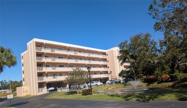9510 Harbor Greens Way Unit 406, Seminole, FL 33776 - view of apartment building / complex featuring uncovered parking