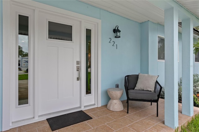 221 42nd Ave, St Pete Beach, FL 33706 - property entrance featuring covered porch and stucco siding
