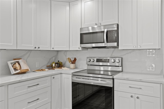 221 42nd Ave, St Pete Beach, FL 33706 - kitchen featuring stainless steel appliances and white cabinets