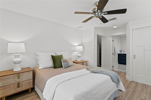 221 42nd Ave, St Pete Beach, FL 33706 - bedroom with light wood finished floors, ensuite bath, and ceiling fan