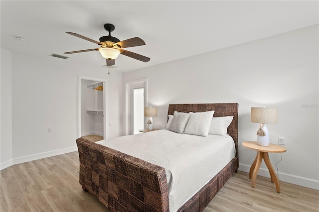 221 42nd Ave, St Pete Beach, FL 33706 - bedroom featuring light wood-style flooring, ceiling fan, a walk in closet, and a closet