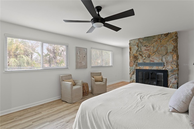221 42nd Ave, St Pete Beach, FL 33706 - bedroom featuring wood finished floors, a stone fireplace, and a ceiling fan