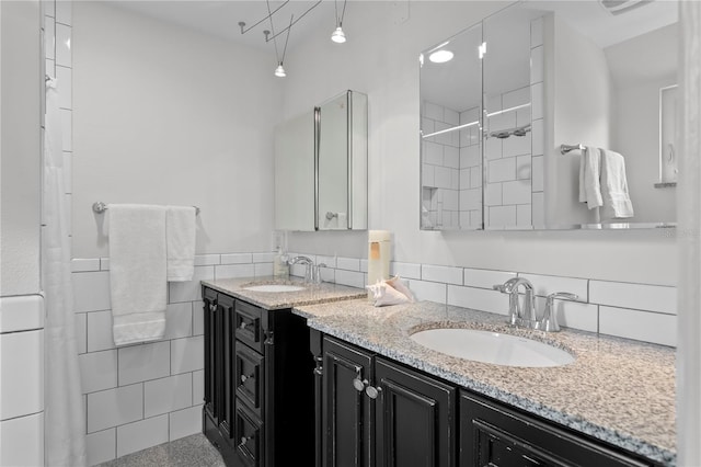 221 42nd Ave, St Pete Beach, FL 33706 - bathroom featuring double vanity, tile walls, tiled shower, and a wainscoted wall
