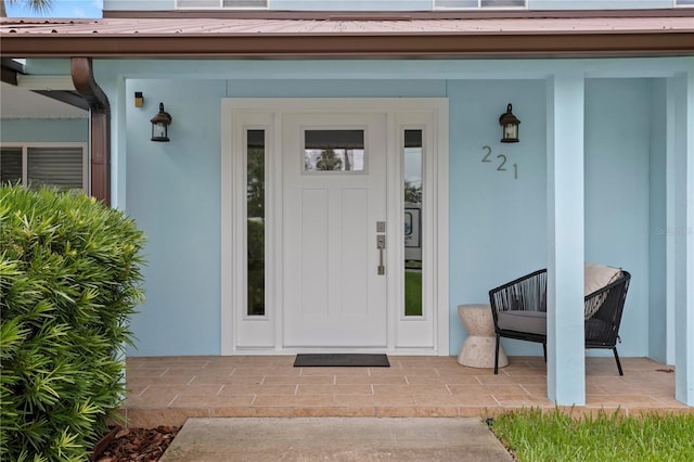 221 42nd Ave, St Pete Beach, FL 33706 - entrance to property featuring a metal roof, stucco siding, and a porch