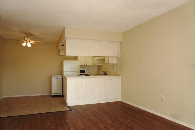 4329 Tahitian Gardens Cir Unit B, Holiday, FL 34691 - kitchen with white appliances, a peninsula, tasteful backsplash, a ceiling fan, and dark wood-type flooring