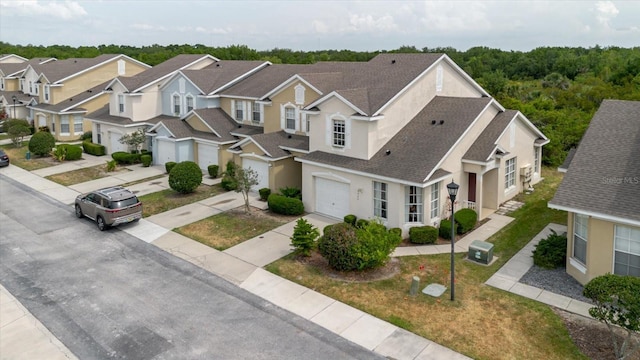 6260 Olivedale Dr, Riverview, FL 33578 - view of front facade with stucco siding, concrete driveway, roof with shingles, a garage, and a residential view