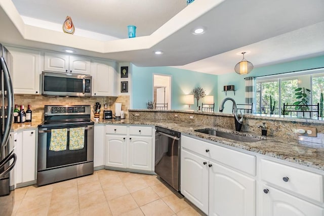 1140 S Pointe Alexis Dr, Tarpon Springs, FL 34689 - kitchen featuring stainless steel appliances, light stone counters, tasteful backsplash, white cabinets, and recessed lighting