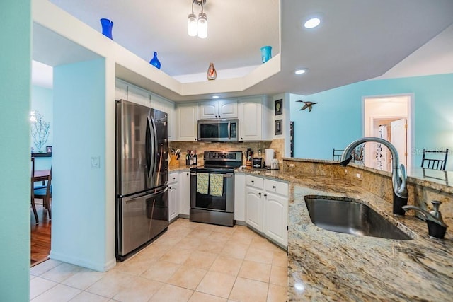 1140 S Pointe Alexis Dr, Tarpon Springs, FL 34689 - kitchen featuring appliances with stainless steel finishes, light stone countertops, light tile patterned flooring, backsplash, and recessed lighting