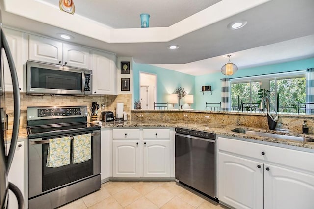1140 S Pointe Alexis Dr, Tarpon Springs, FL 34689 - kitchen featuring stainless steel appliances, light stone countertops, white cabinets, tasteful backsplash, and recessed lighting