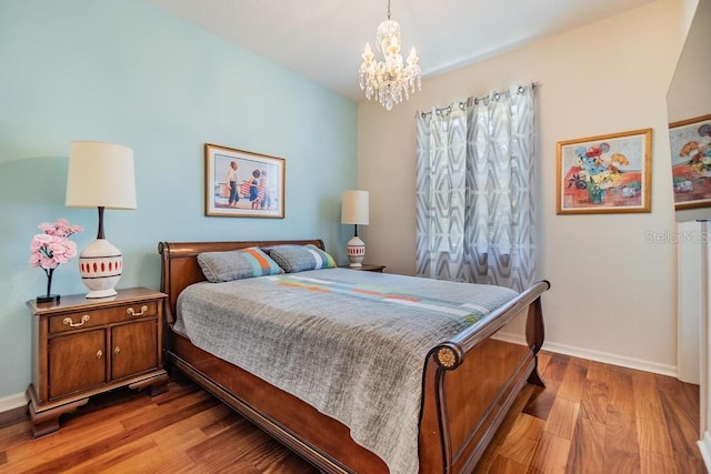 1140 S Pointe Alexis Dr, Tarpon Springs, FL 34689 - bedroom featuring wood finished floors and a chandelier