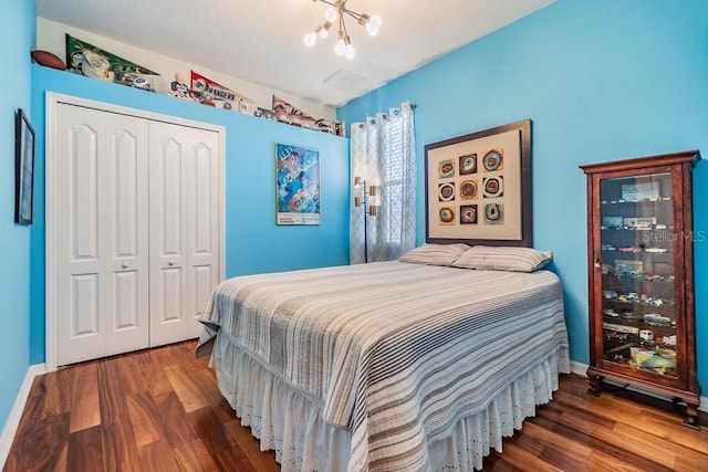 1140 S Pointe Alexis Dr, Tarpon Springs, FL 34689 - bedroom with a closet, wood finished floors, and a chandelier