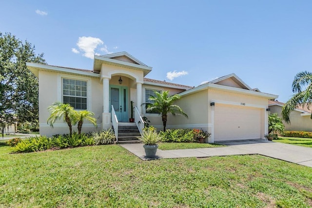 1140 S Pointe Alexis Dr, Tarpon Springs, FL 34689 - view of front facade with stucco siding, a front yard, an attached garage, and concrete driveway