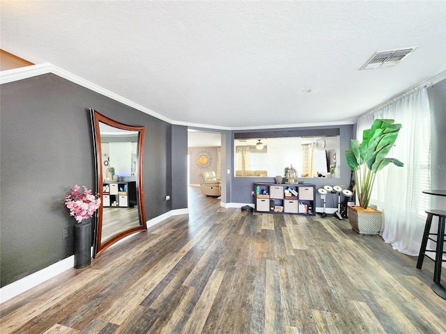 3112 Kearns Rd, Mulberry, FL 33860 - living area featuring wood finished floors, plenty of natural light, ornamental molding, and a textured ceiling
