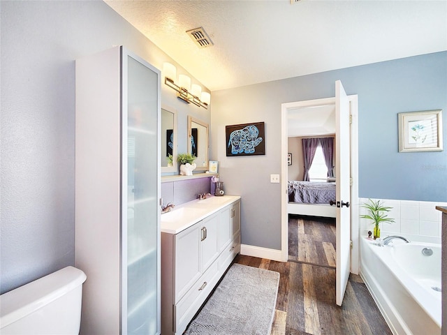 3112 Kearns Rd, Mulberry, FL 33860 - bathroom with vanity, a garden tub, wood finished floors, ensuite bathroom, and a textured ceiling