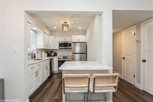 2207 S Carolina Ave Unit 10, Tampa, FL 33629 - kitchen featuring appliances with stainless steel finishes, dark wood-type flooring, backsplash, white cabinetry, and light stone countertops
