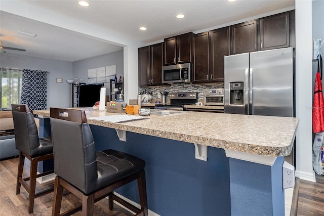 255 Annabelle Way, Davenport, FL 33837 - kitchen with stainless steel appliances, open floor plan, dark wood-style flooring, dark brown cabinets, and recessed lighting