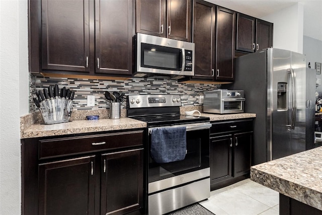 255 Annabelle Way, Davenport, FL 33837 - kitchen featuring appliances with stainless steel finishes, decorative backsplash, light countertops, and dark brown cabinets