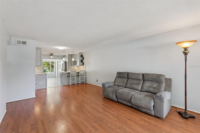 2370 Jamaican St Unit 44, Clearwater, FL 33763 - living area featuring wood finished floors, a textured ceiling, and ceiling fan