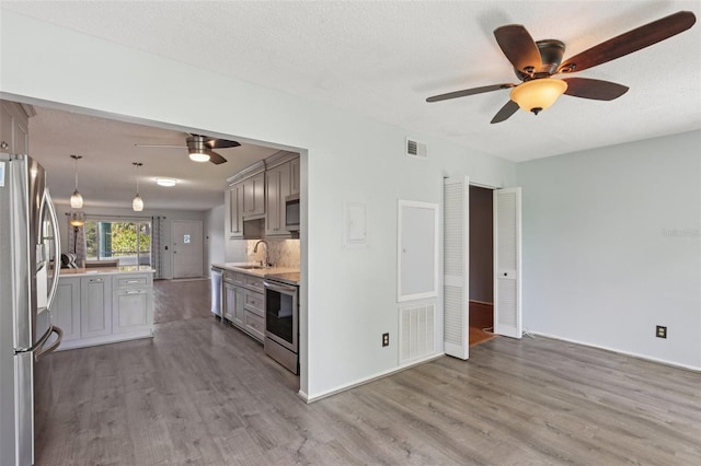 2370 Jamaican St Unit 44, Clearwater, FL 33763 - kitchen with stainless steel appliances, a ceiling fan, wood finished floors, and gray cabinets