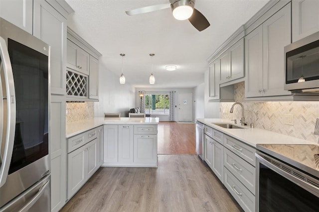 2370 Jamaican St Unit 44, Clearwater, FL 33763 - kitchen with appliances with stainless steel finishes, light wood-type flooring, light countertops, a ceiling fan, and gray cabinetry