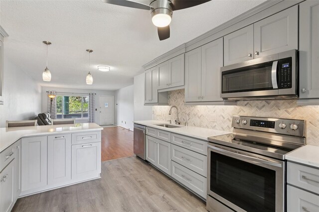 2370 Jamaican St Unit 44, Clearwater, FL 33763 - kitchen with appliances with stainless steel finishes, gray cabinets, decorative backsplash, light wood-style floors, and light countertops